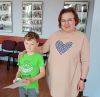 Dziecko pozuje do zdjęcia z instruktorką i dyplomem